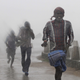 People run for shelter as heavy rain and wind gusts rip through the Bay of Bengal coast at Gopalpur, Orissa.